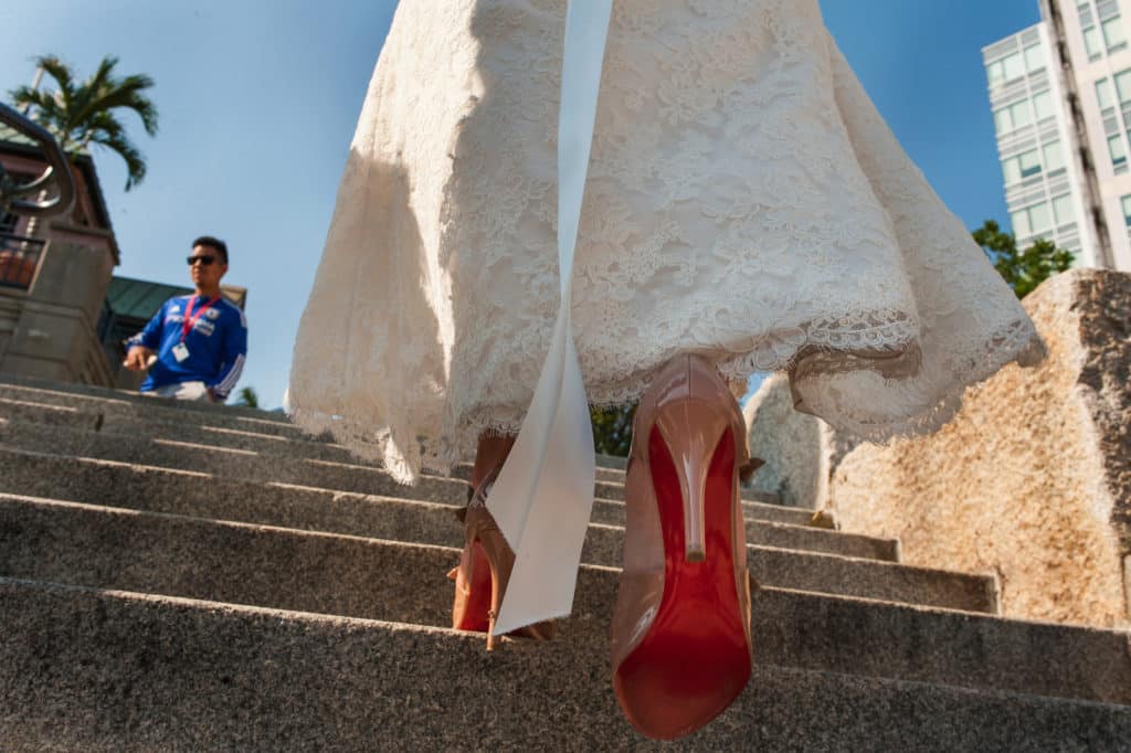 cute detail of the bride walking to the portrait location at Waterplace Park in Providence RI, showing of the Louboutin red of her wedding shoes
