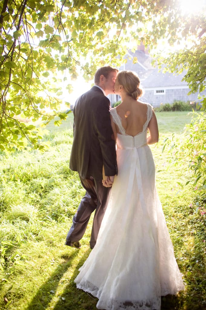 bride and groom kissing walking away from their ceremony, newly wed, taken at a private estate in Maine