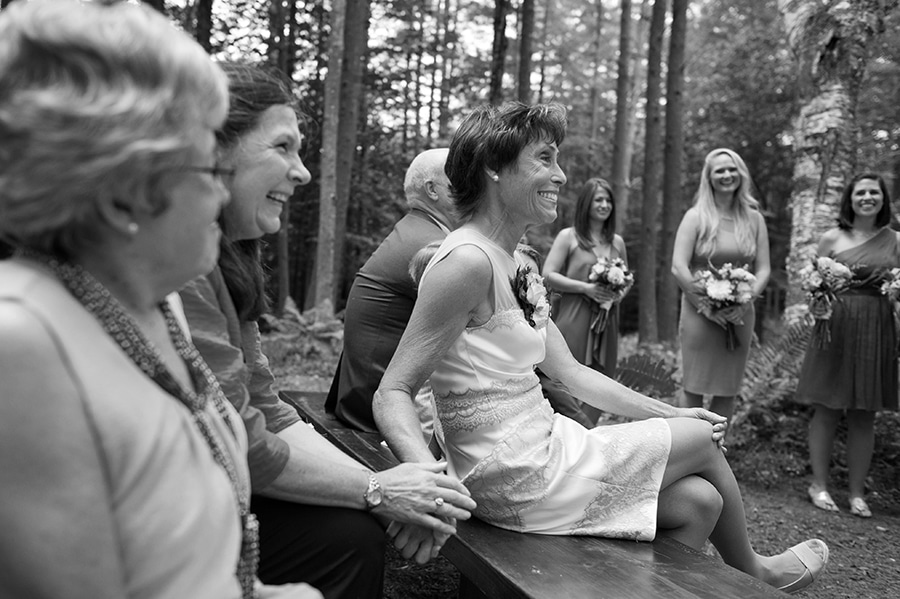 mother of the bride holding the hand of close friends as she watches her daughter marry her love, private estate in New Hampshire